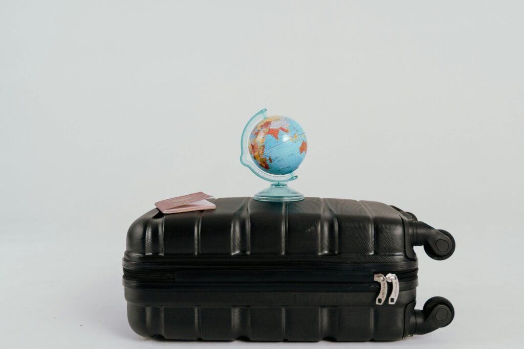 A globe placed on a black suitcase symbolizing global travel and adventure.